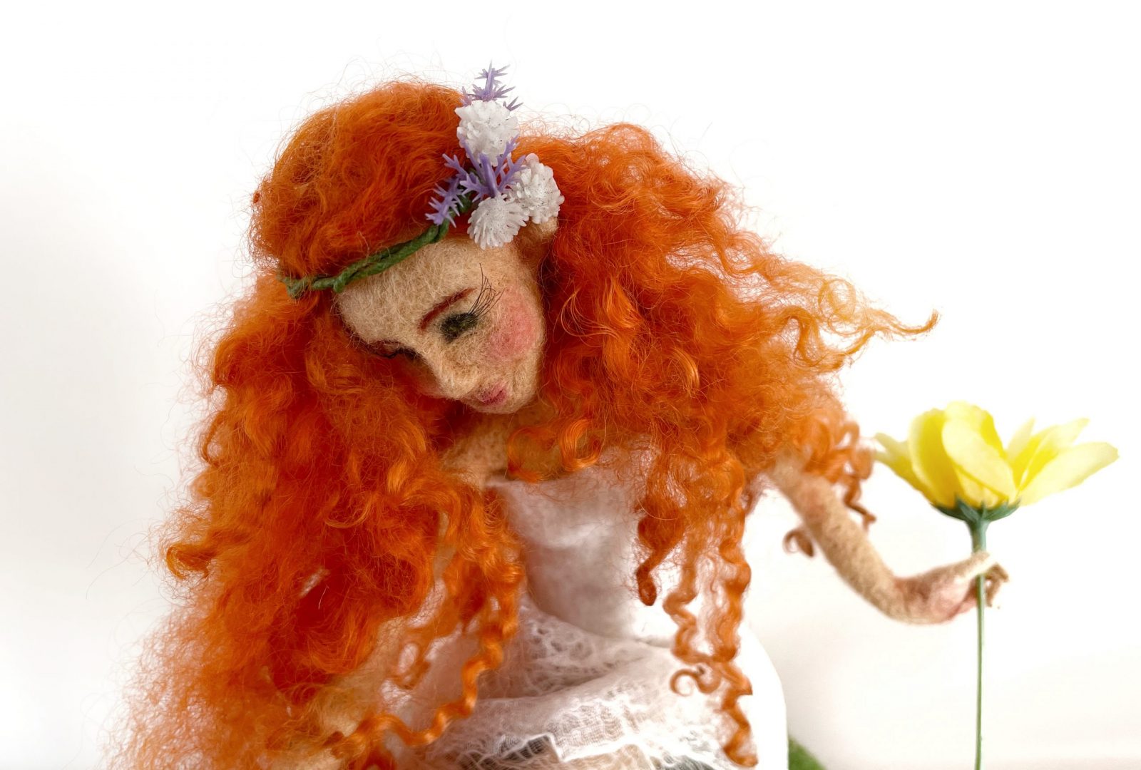 bambola elfa di lana con capelli ricci rossi e corona di fiori tra i capelli, fiore giallo tra le mani