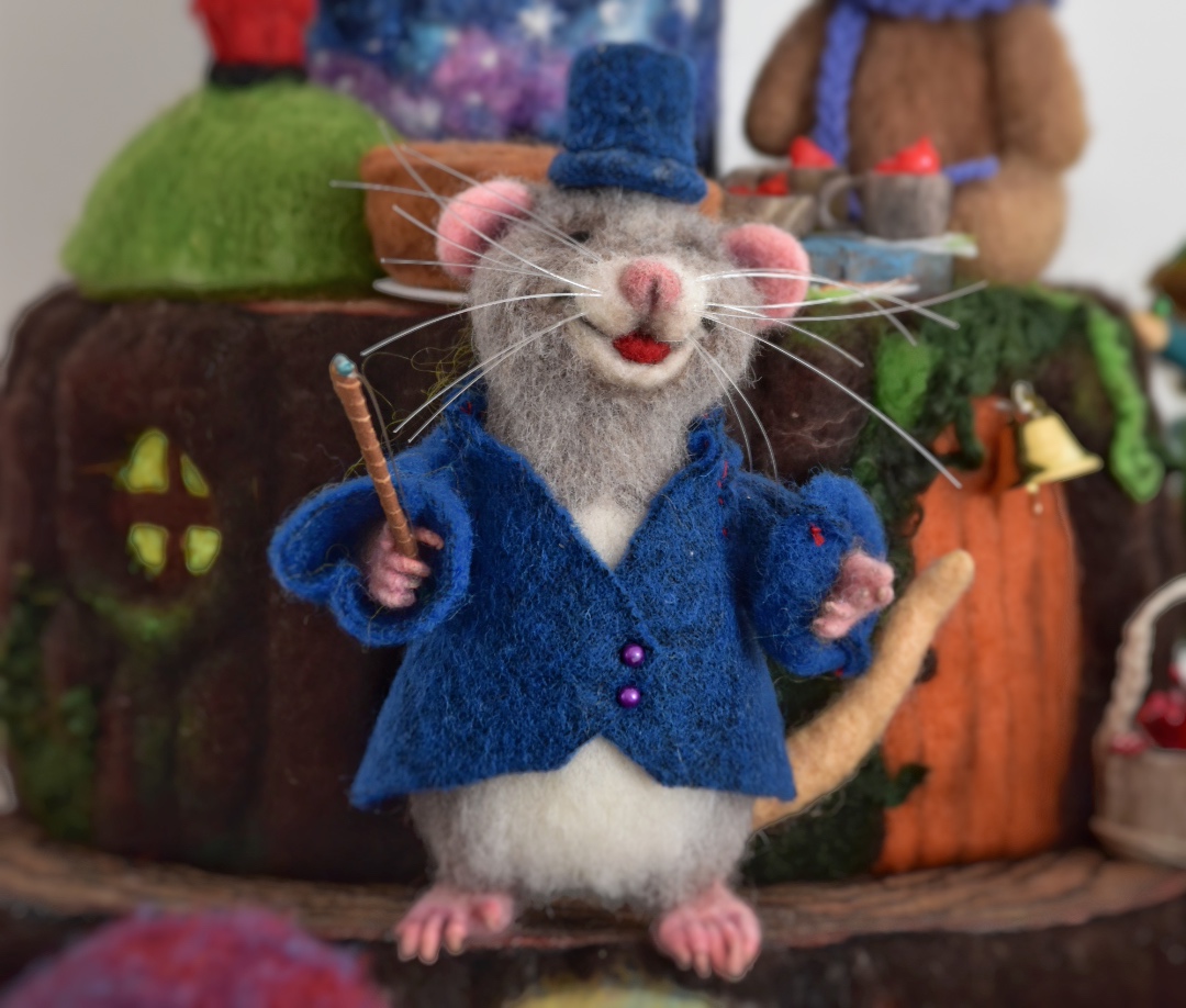 topo di lana vestito che dirige l'orchestra con giacca e cappello blu, scultura di lana